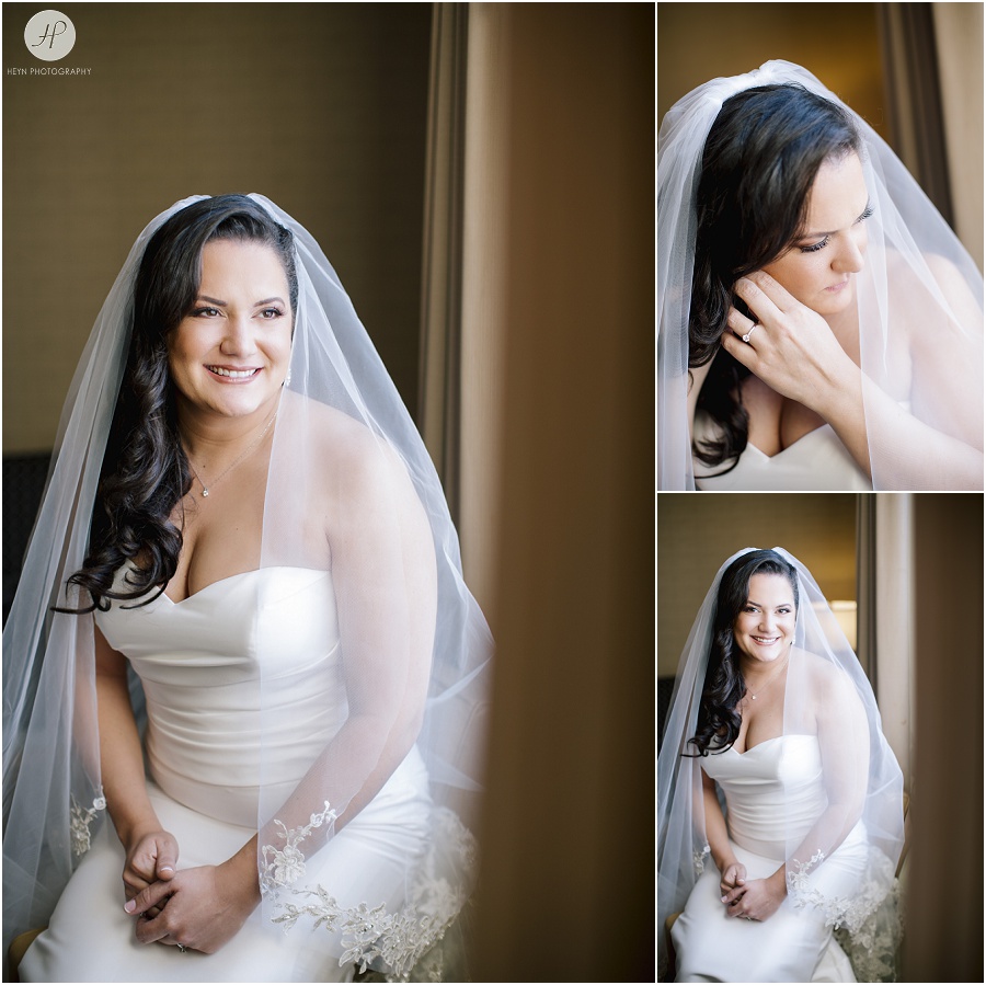 smiling bride looks out window before wedding at the berkeley hotel in asbury park 