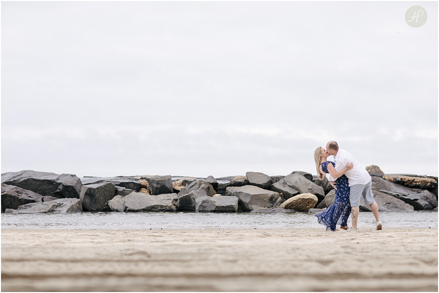  couple kissing and dipping on beach in Asbury Park engagement session jersey shore 