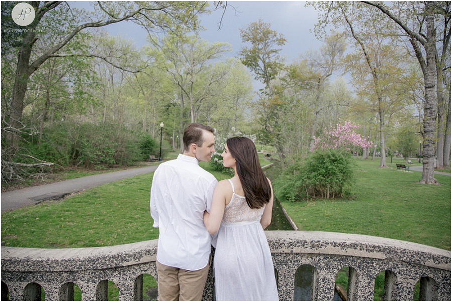 couple on bridge in spring in park in downtown westfield engagement session new jersey