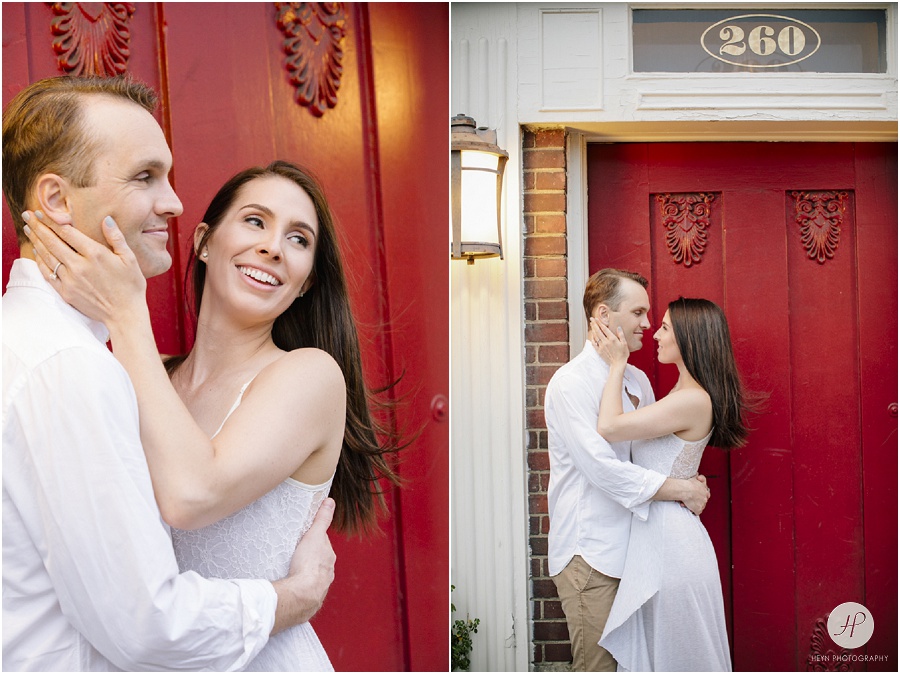 couple snuggling by red door in downtown westfield engagement session new jersey