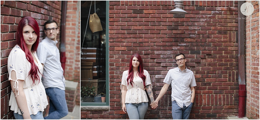 engaged couple in front of brick wall at downtown asbury park engagement session 