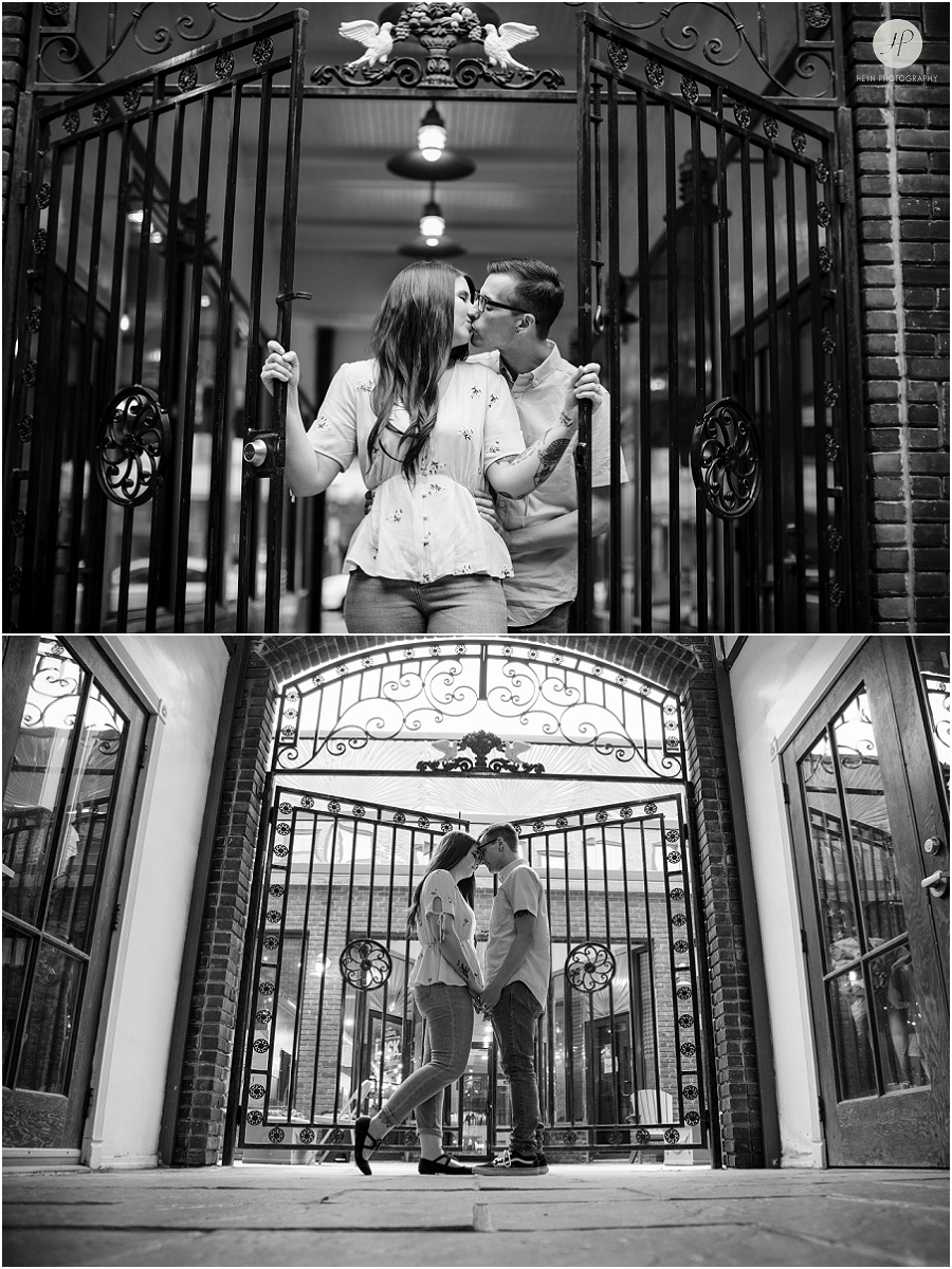 black and white of engaged couple by gate at downtown asbury park engagement session 