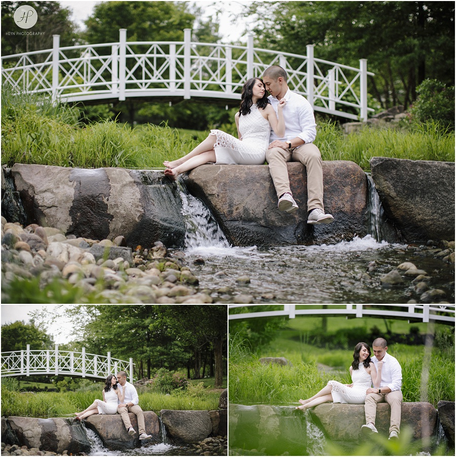 engaged couple on rocks under bridge at sayen gardens new jersey shoot 