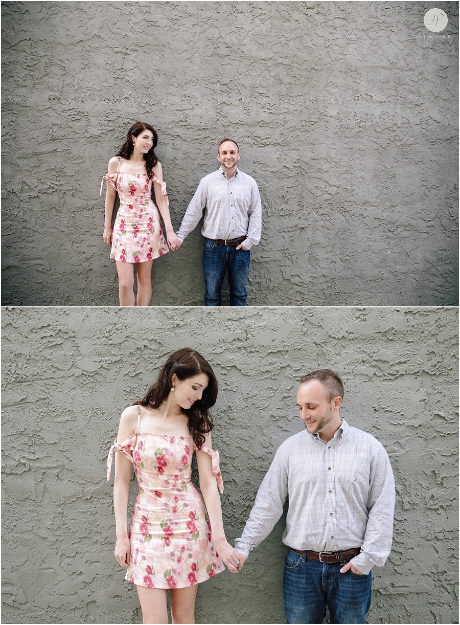 engaged couple by grey wall in downtown spring lake engagement session