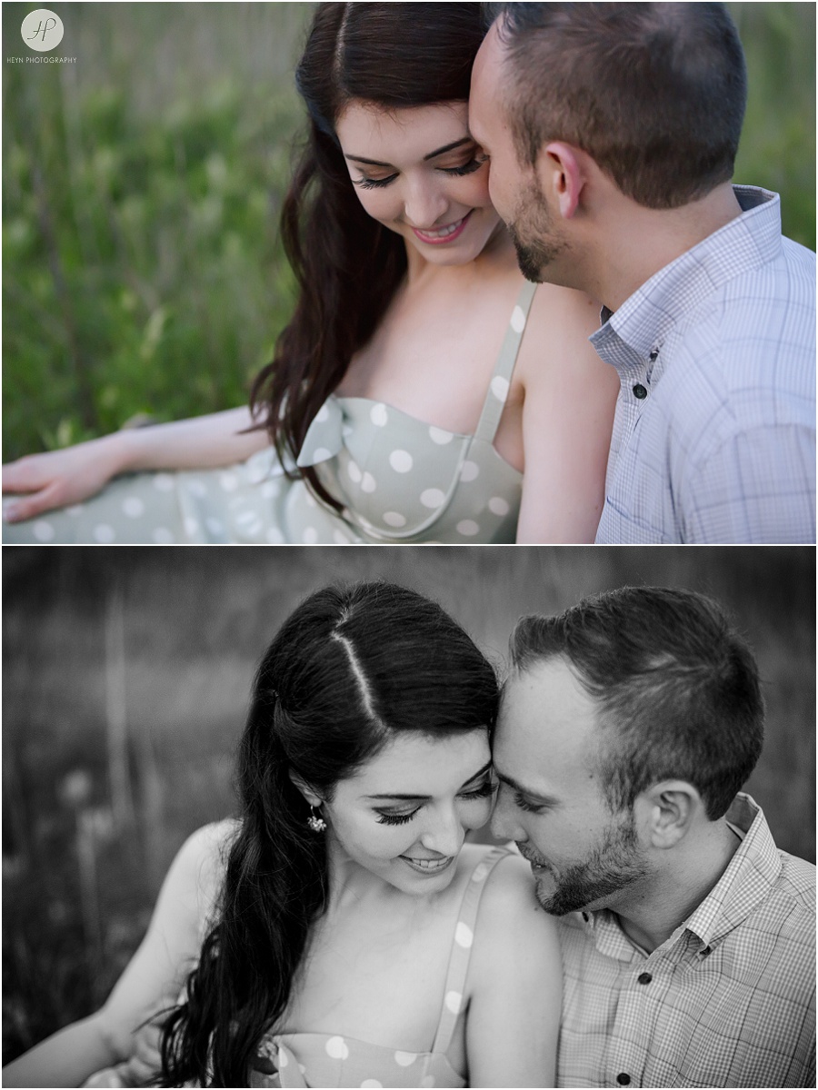  engaged couple sitting in tall grass at dusk in downtown spring lake engagement session