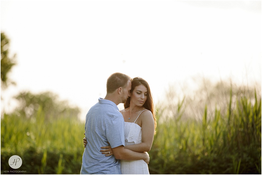 engaged couple in field during sunset in manasquan beach engagement shoot