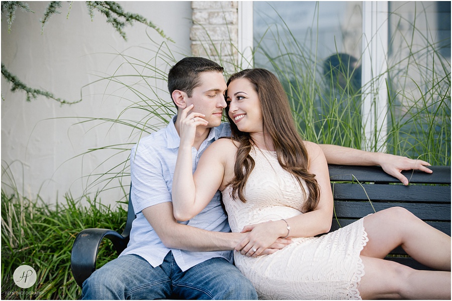 engaged couple on bench downtown in spring lake engagement session