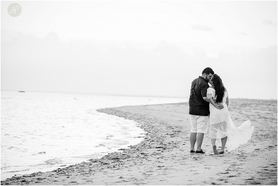 black and white of couple walking on beach at sandy hook engagement session