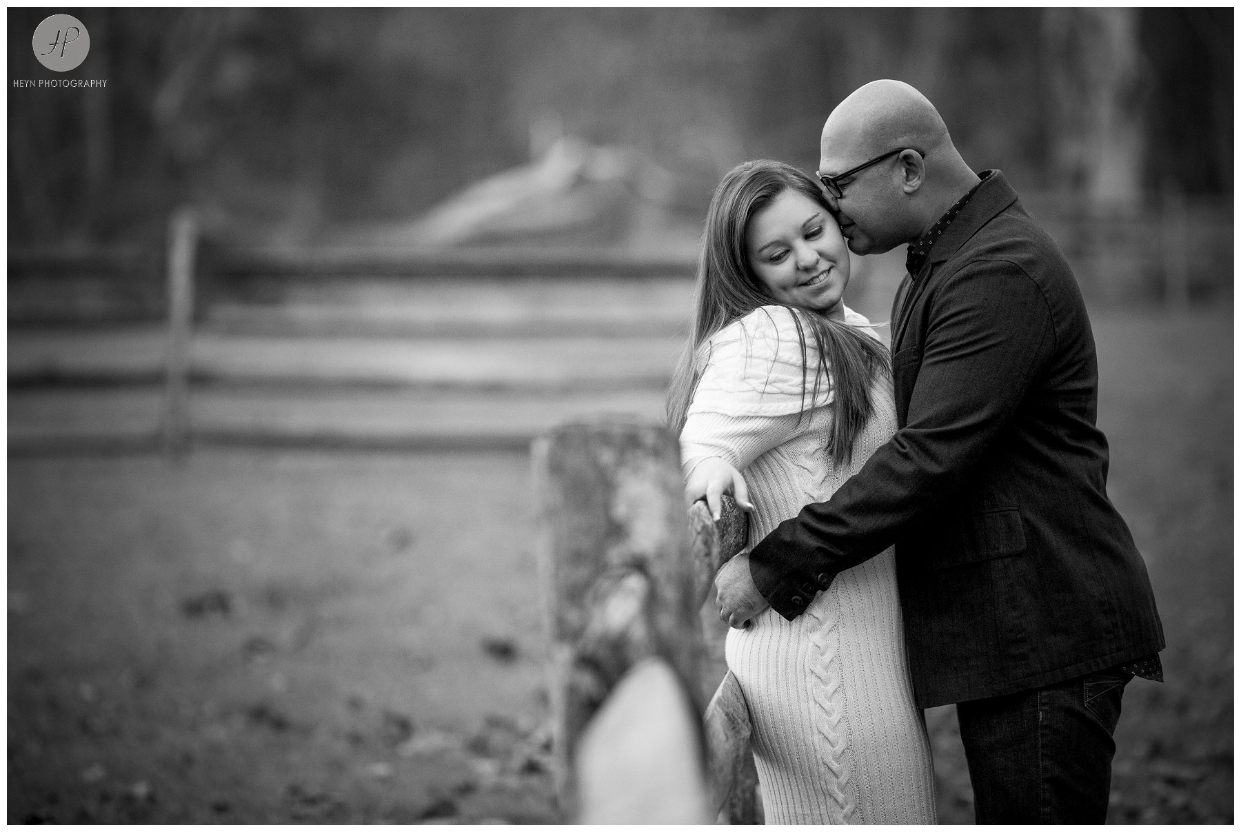 couple by fence at allaire state park engagement session in New Jersey