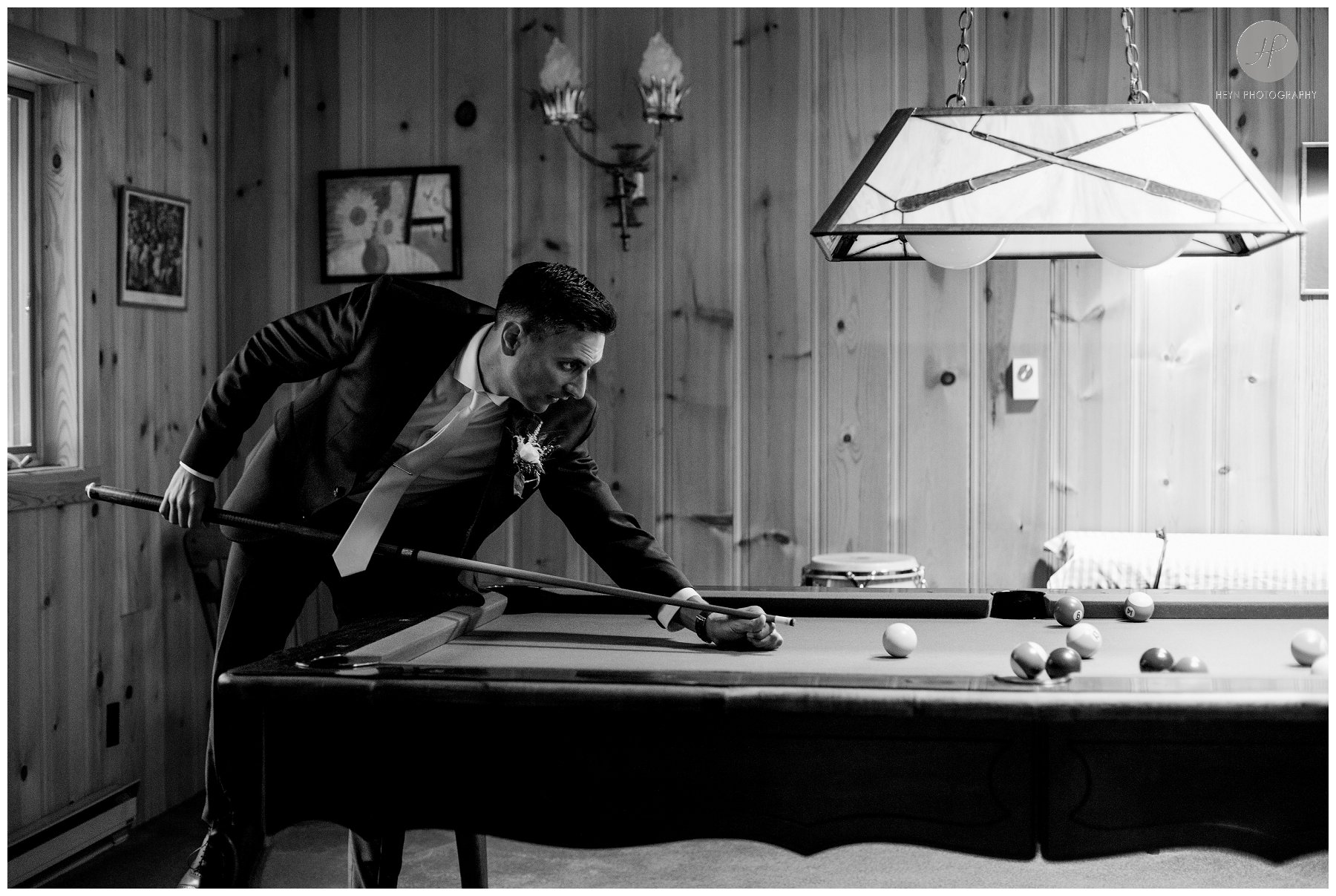 black and white of groom playing pool at stone tavern farm wedding in the catskills new york