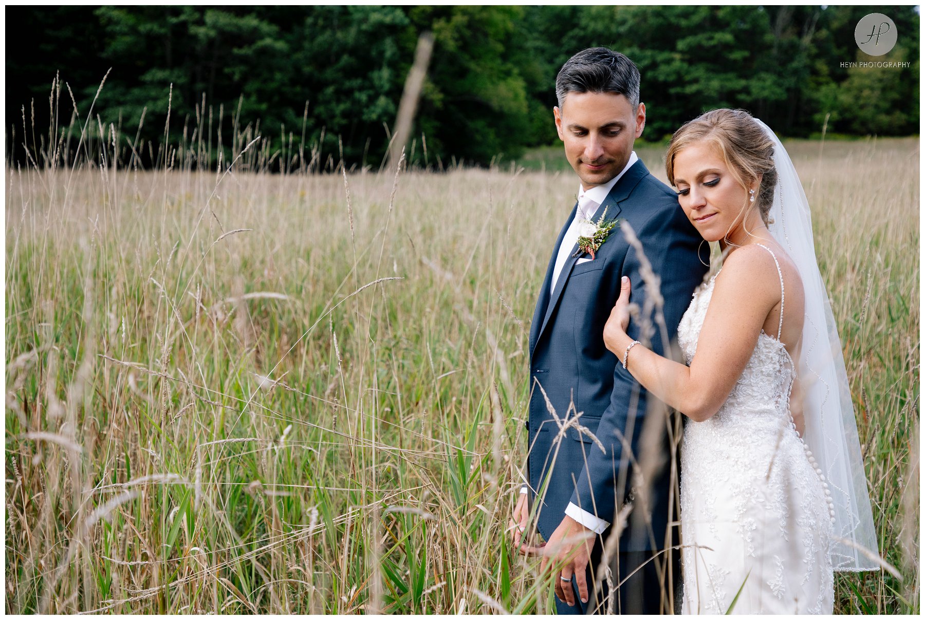 bride and groom in tall grass at stone tavern farm wedding in the catskills new york