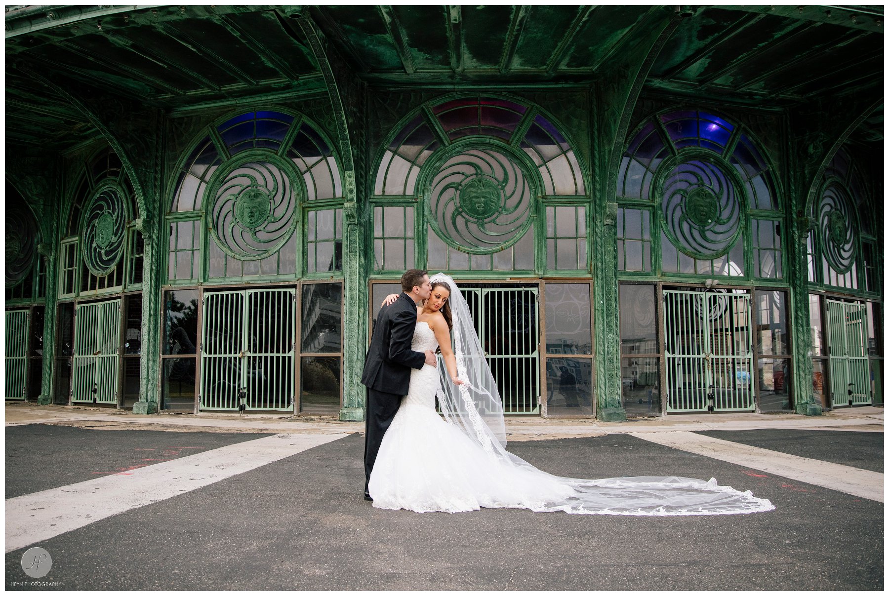 groom kissing bride in front of asbury park carousel house before clarks landing yacht club wedding