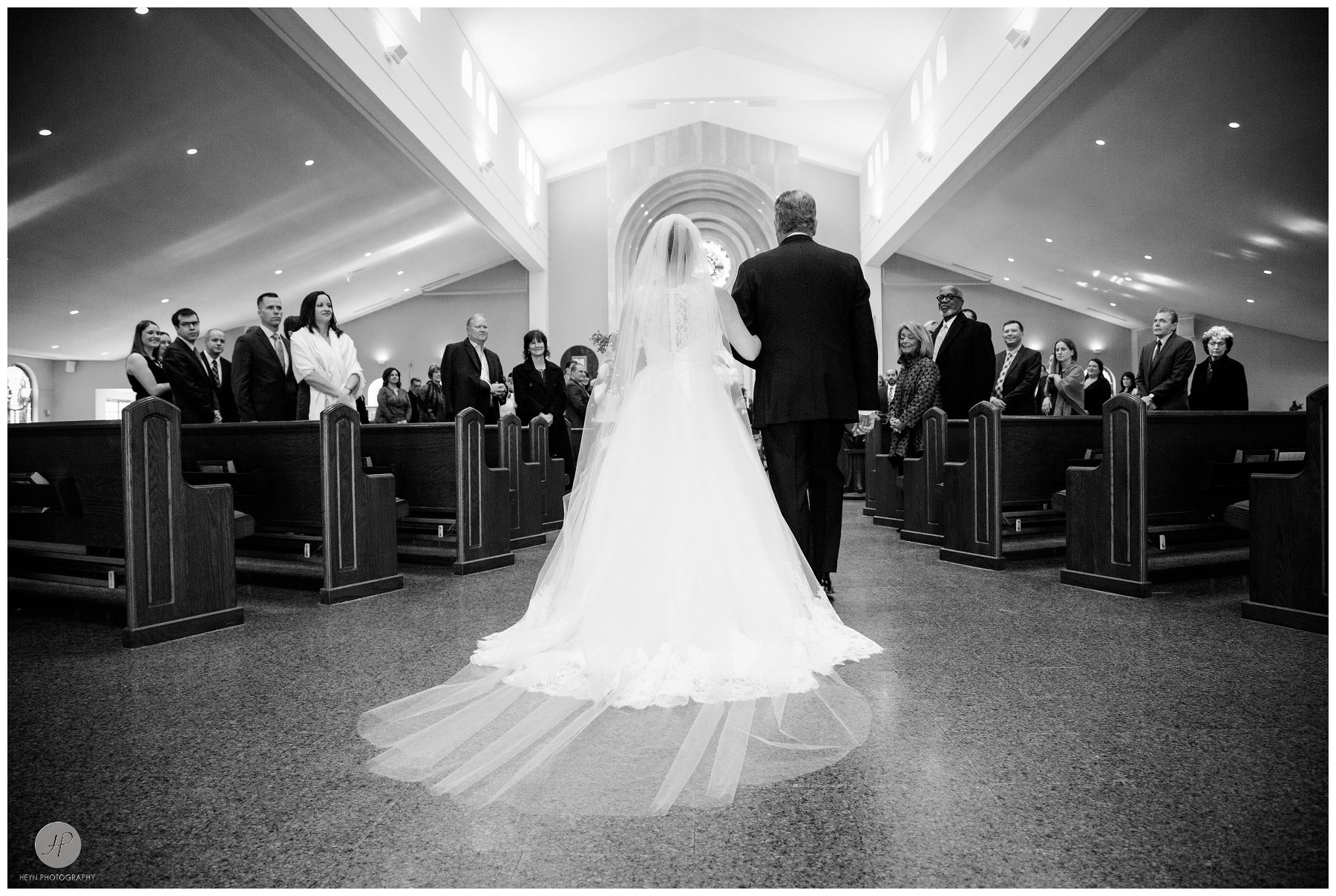 black and white photo bride walking down the aisle