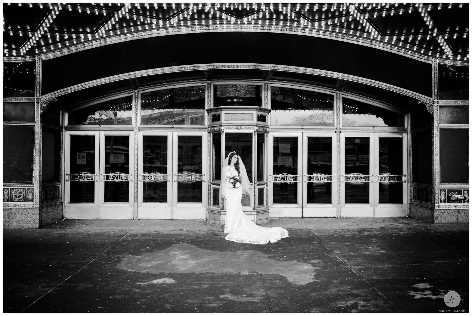 black and white photo of bride in front of landmark loews jersey theatre wedding