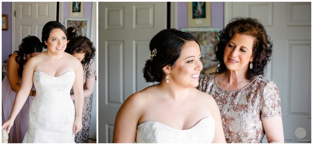 mother and maid of honor helping bride get into gown