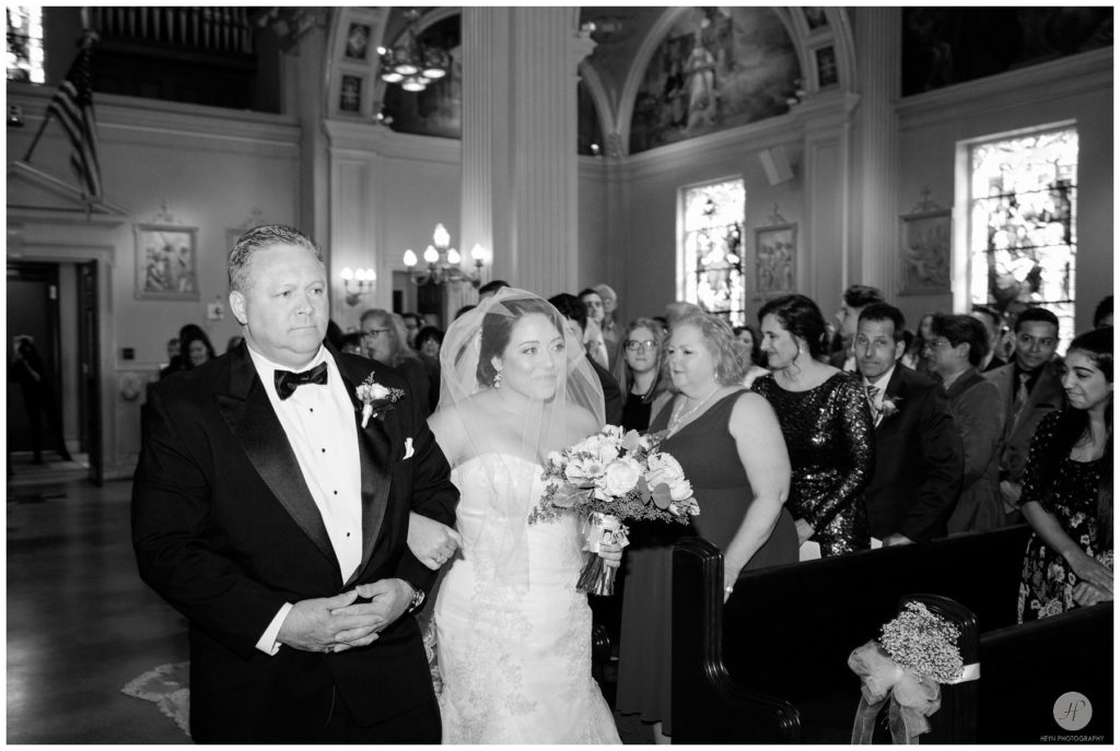 black and white photo of father walking bride down the aisle