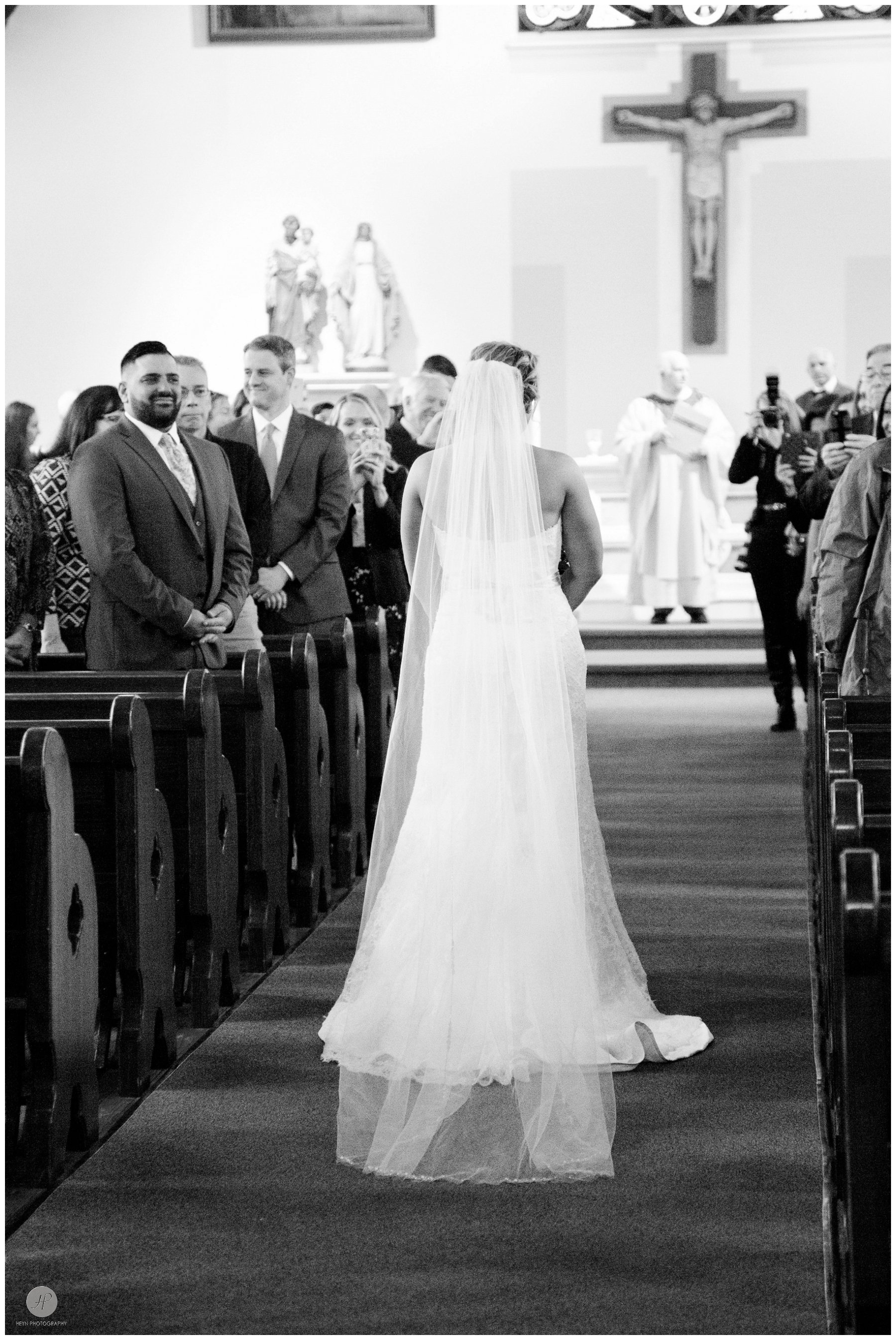 black and white photo of bride walking down the aisle