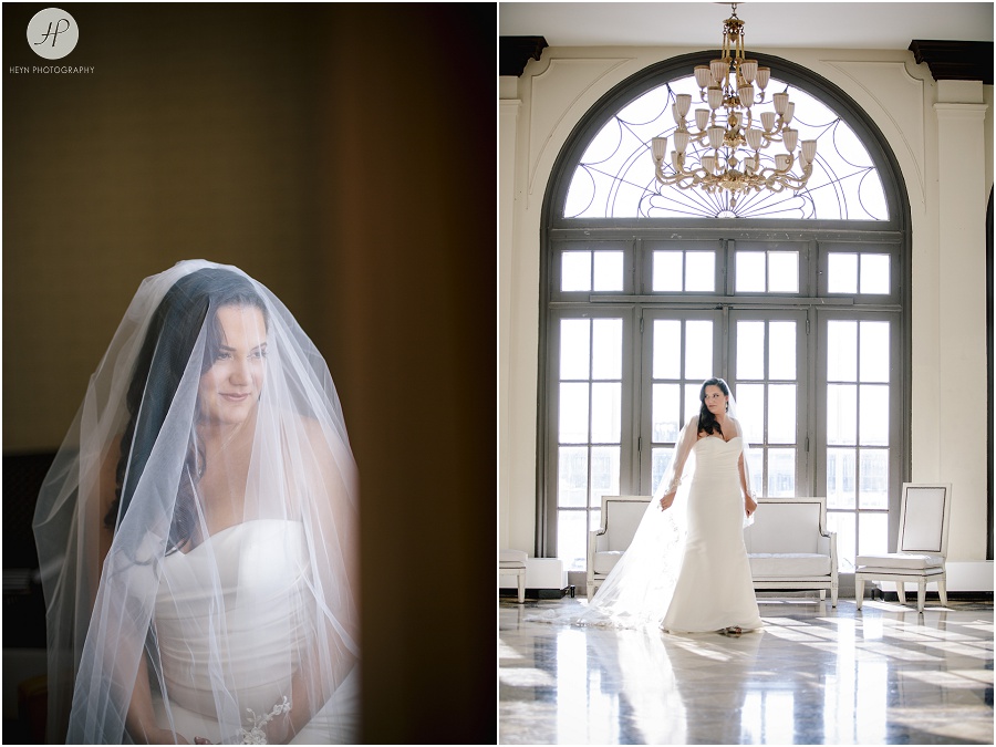 bride stands in front of large window with long veil at berkeley hotel in asbury park 