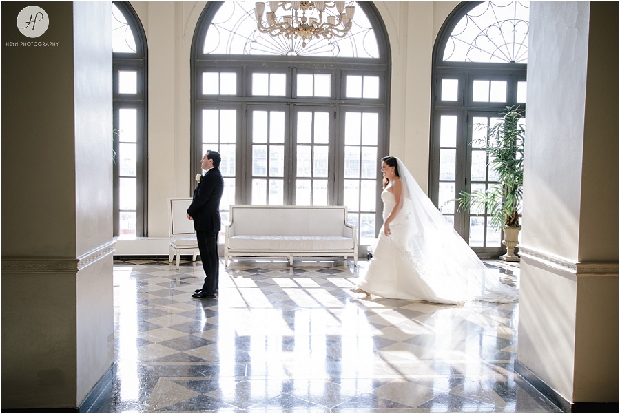 bride walking up to groom for first look in large lobby with big windows at berkeley oceanfront hotel in asbury park 