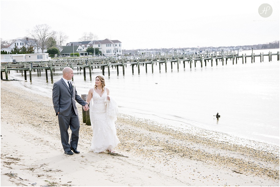 Bride and groom walking on beach at clarks landing yacht club wedding in point pleasant nj