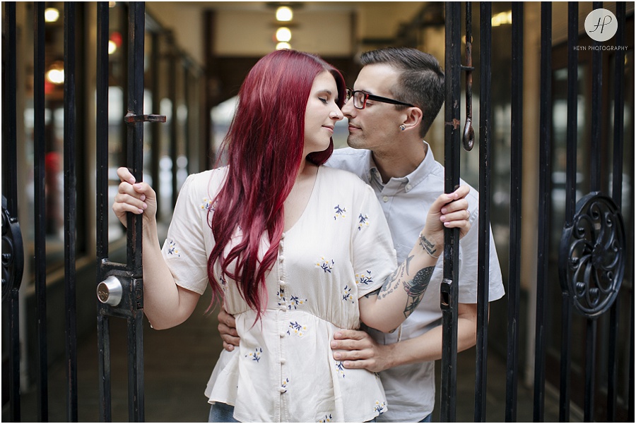 engaged couple by gate at downtown asbury park engagement session 