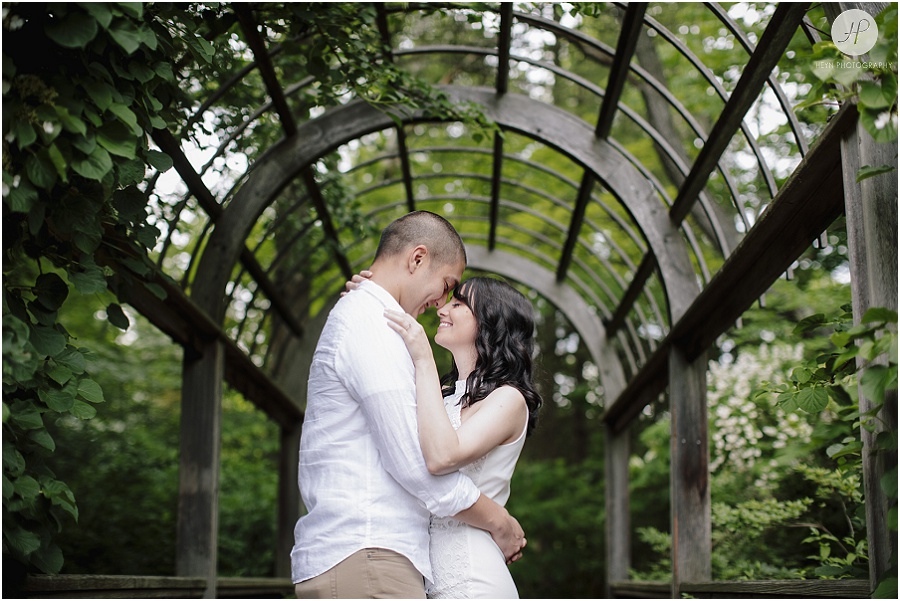 engaged couple under arch at sayen gardens new jersey shoot 