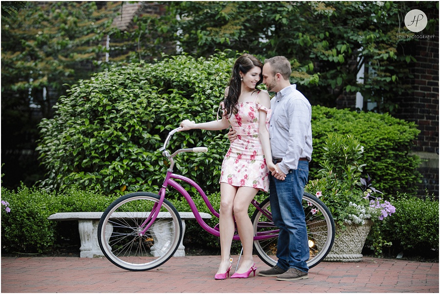engaged couple by bike in park for downtown spring lake engagement session