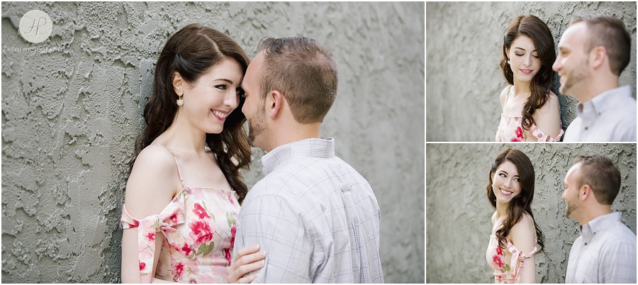 engaged couple by grey wall in downtown spring lake engagement session