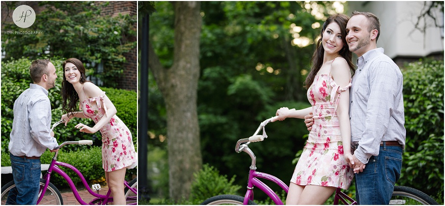 engaged couple on pink bicycle in downtown spring lake engagement session