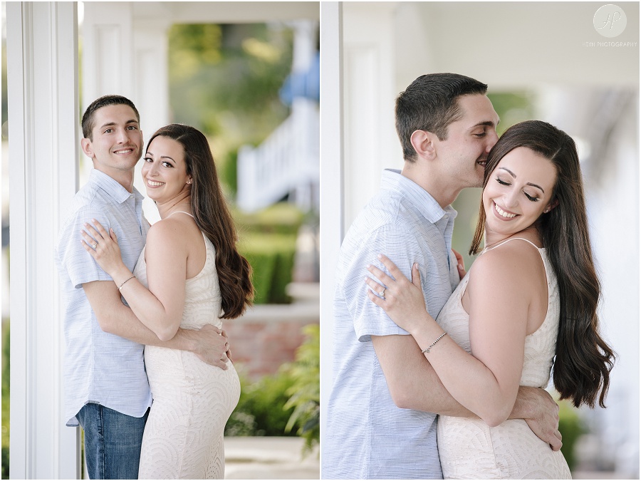 engaged couple by white house in spring lake engagement session