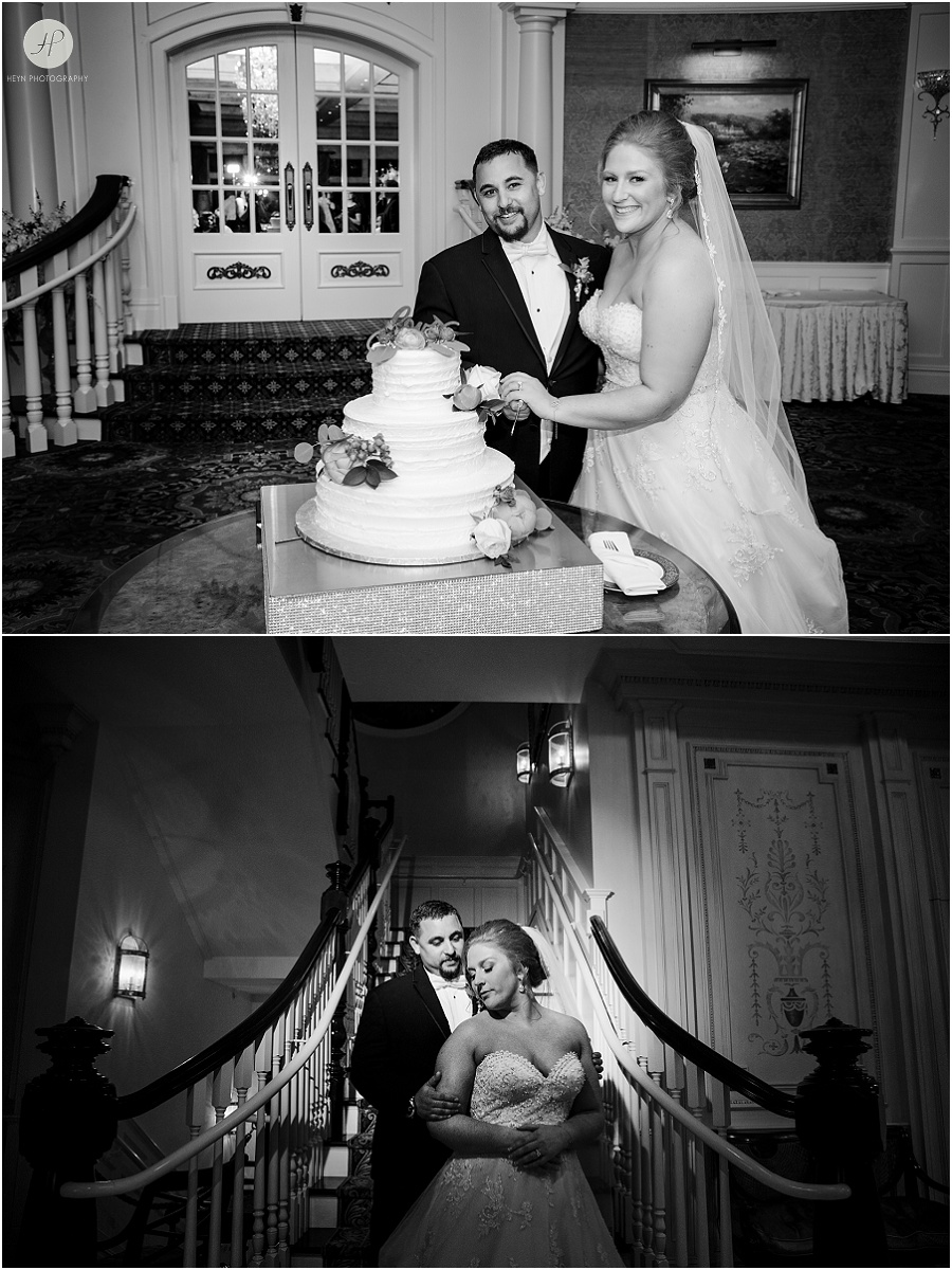 black and white of bride and groom cutting cake at clarks landing yacht club wedding