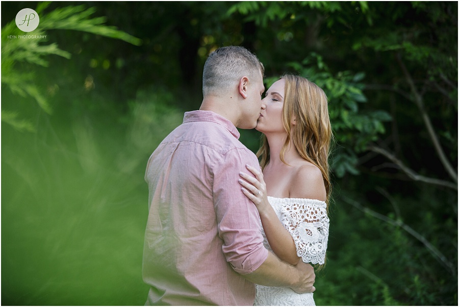 couple kissing in tropical grass on manasquan beach engagement 