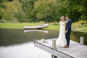 bride and groom standing on dock at stone tavern farm wedding